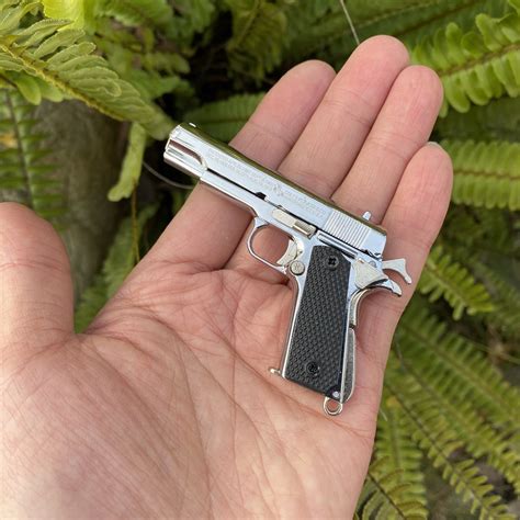 A 1911 pistol with a tactical light and laser sight