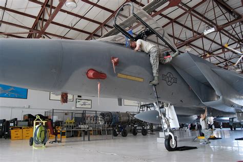 Technicians performing maintenance on an F-15 fighter jet