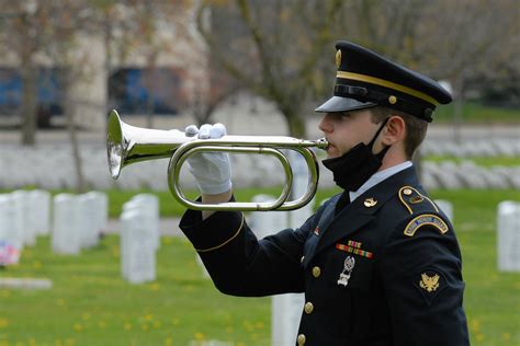 A military funeral with a bugler playing Taps