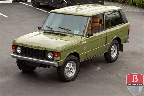 A classic Range Rover driving on a rugged terrain