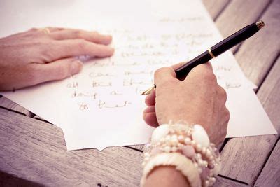 A child sitting at a desk, pen in hand, writing a letter to Santa Claus