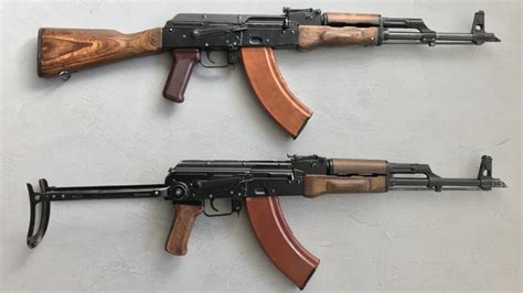 AK 47 vs M16 rifles on a wooden table