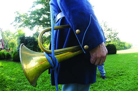 A bugler blows the bugle to signal the start of the day