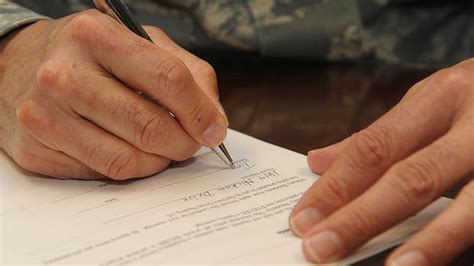 A soldier in uniform, speaking with a counselor.