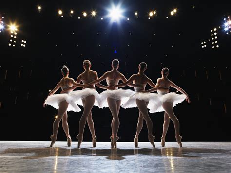 A group of ballerinas on stage, performing a beautiful routine