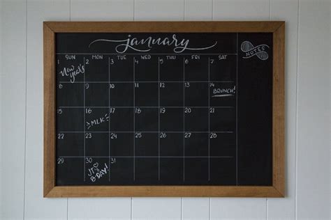 A chalkboard calendar in a backyard