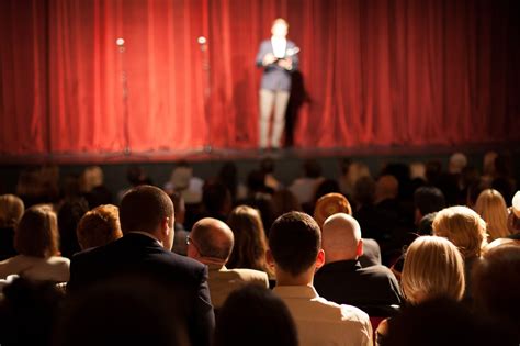 A crowd of people laughing at a live comedy show