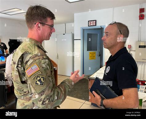 A commander coordinating with partners, with a map or chart in the background