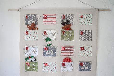 A person sewing pockets onto a fabric advent calendar