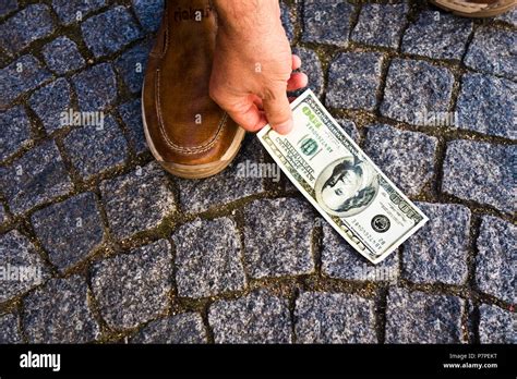 A person picking up a quarter from the ground