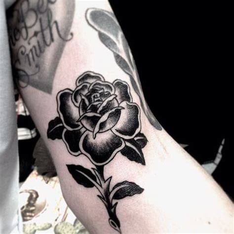 A tattoo artist at work, creating a custom rose black design