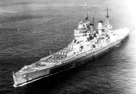 King George V battleship firing its 14-inch guns during a naval engagement