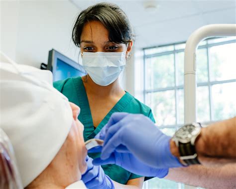 Maxillofacial Surgeon Examining Patient