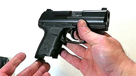 A person holding a.45 caliber handgun with a confident expression