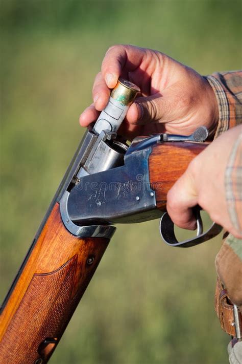 A person loading a shotgun