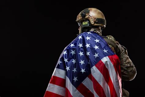 A soldier with a flag, smiling and proud