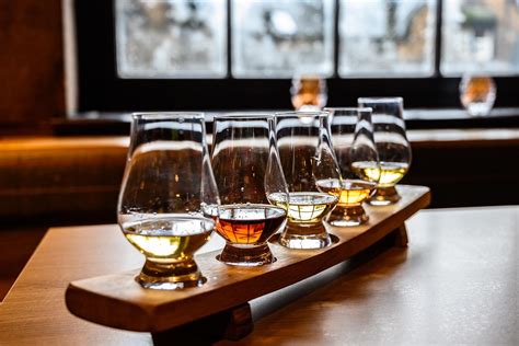 Person tasting whiskey with a notebook